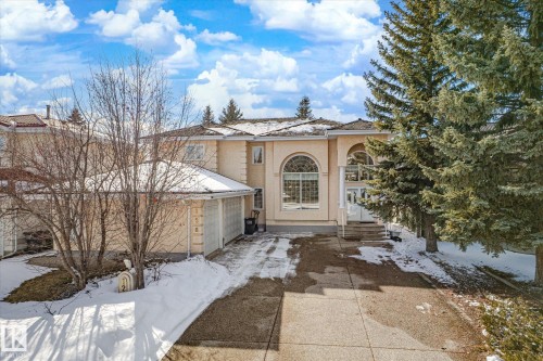 The property features an architectural style with arched windows and a front entrance staircase - 128 Weaver Drive, Edmonton, AB - Outdoor