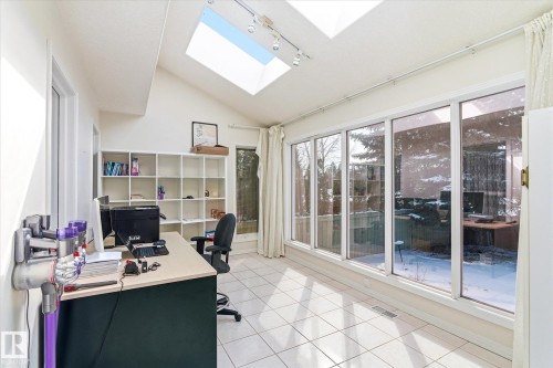 This bright room features a vaulted ceiling with two skylights, track lighting, and tiled flooring - 128 Weaver Drive, Edmonton, AB - Indoor Photo Showing Office