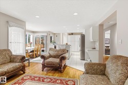 Living area featuring hardwood flooring, a decorative area rug, and recessed lighting - 