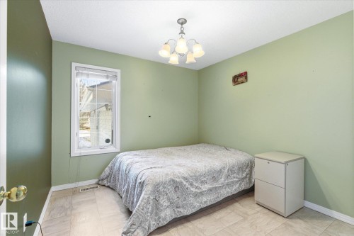 This room features light green walls and a window with white trim - 128 Weaver Drive, Edmonton, AB - Indoor Photo Showing Bedroom