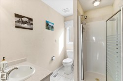 Bathroom with a vanity, toilet, and a shower stall with a glass door - 