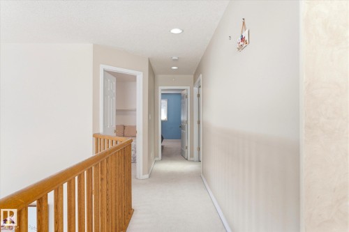 Hallway featuring light-colored carpeting, recessed lighting, and a wooden handrail - 128 Weaver Drive, Edmonton, AB - Indoor Photo Showing Other Room