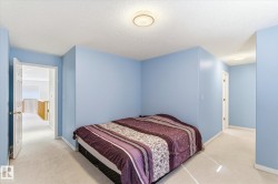 This room features light blue walls, white trim, and light-colored carpet flooring - 