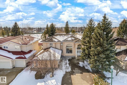 This property features a stucco exterior, a tiled roof, and a paved driveway - 128 Weaver Drive, Edmonton, AB - Outdoor