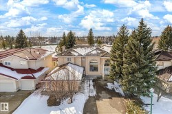 This property features a stucco exterior, a tiled roof, and a paved driveway - 