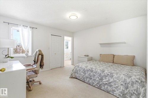This room features light-colored carpeting, a window providing natural light, and a ceiling light fixture - 128 Weaver Drive, Edmonton, AB - Indoor Photo Showing Bedroom