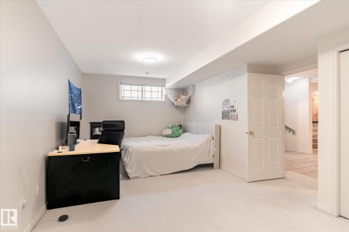 This room features light-colored carpeting, a window with gridded panes, and recessed lighting - 128 Weaver Drive, Edmonton, AB - Indoor Photo Showing Bedroom