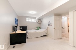 This room features light-colored carpeting, a window with gridded panes, and recessed lighting - 