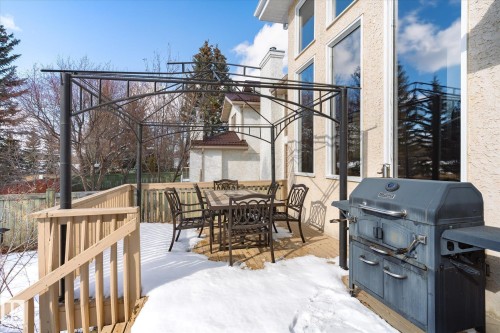 The property features a spacious wooden deck with a black metal pergola structure, offering an outdoor dining area - 128 Weaver Drive, Edmonton, AB - Outdoor With Deck Patio Veranda With Exterior