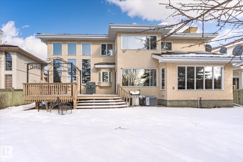 The property features a spacious rear deck with wooden railings and steps, offering direct access to the exterior - 128 Weaver Drive, Edmonton, AB - Outdoor