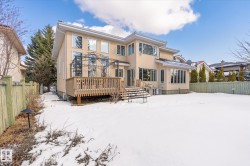 This property features a spacious rear exterior with a wooden deck, a metal gazebo, and numerous windows - 