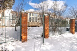 The property features a gated entrance with brick pillars and a metal fence - 