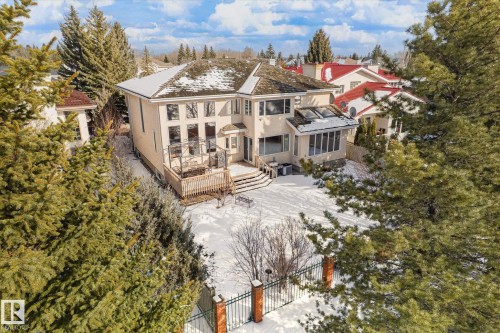 The property features a large exterior with an expansive deck, a sunroom with skylights, and a spacious yard - 128 Weaver Drive, Edmonton, AB - Outdoor