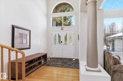The property features a grand entryway with double doors and an arched transom window, complemented by a large decorative column - 
