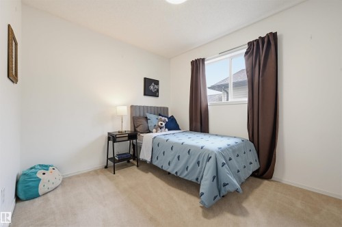 Bright room featuring neutral carpeting, white walls, and a window with brown drapery - 21 Escada Close, St. Albert, AB - Indoor Photo Showing Bedroom