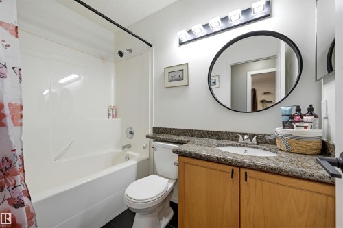 Bathroom vanity featuring a built-in sink, stone-finish countertop, and wood-finish cabinetry - 21 Escada Close, St. Albert, AB - Indoor Photo Showing Bathroom