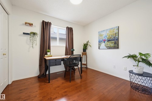 Warm wood-finish flooring extends throughout this room, complemented by a single window with dark drapery - 21 Escada Close, St. Albert, AB - Indoor Photo Showing Office