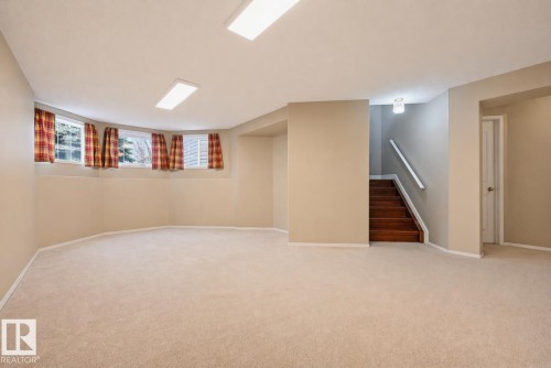 Spacious lower-level room featuring light tan walls, cream-colored carpeting, multiple windows, and recessed lighting - 21 Escada Close, St. Albert, AB - Indoor