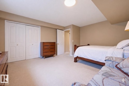 Spacious room with neutral-toned walls, light-colored carpeting, a ceiling-mounted light fixture, and double bi-fold closet doors - 21 Escada Close, St. Albert, AB - Indoor Photo Showing Bedroom
