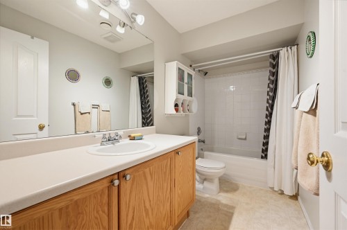 Full bathroom featuring a single vanity with wood-finish cabinetry, a drop-in sink, and a light-toned countertop - 21 Escada Close, St. Albert, AB - Indoor Photo Showing Bathroom