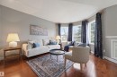 Living space featuring warm wood-finish flooring, light gray wall paint, and a bay window configuration - 21 Escada Close, St. Albert, AB  - Indoor Photo Showing Living Room 