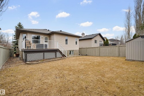 Rear exterior featuring a raised deck with white railings, lattice skirting, and steps descending to the backyard - 21 Escada Close, St. Albert, AB - Outdoor With Deck Patio Veranda