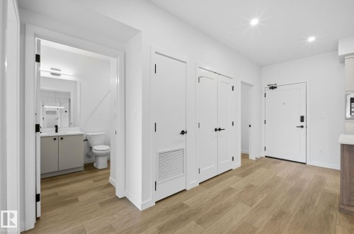 Hallway featuring light wood-finish flooring and recessed lighting - 202 7459 May Common, Edmonton, AB - Indoor