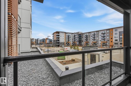 Private balcony with glass railing and gravel-covered surface - 202 7459 May Common, Edmonton, AB - Outdoor With Balcony With Exterior