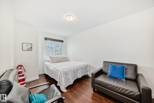 Bedroom featuring wood-finish flooring, a window with horizontal blinds, and a flush-mount ceiling light - 75 Amberly Court, Edmonton, AB - Indoor Photo Showing Bedroom