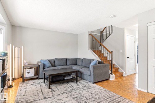 Living area featuring light gray walls and wood-finish flooring - 70 Stirling Road, Edmonton, AB - Indoor Photo Showing Living Room