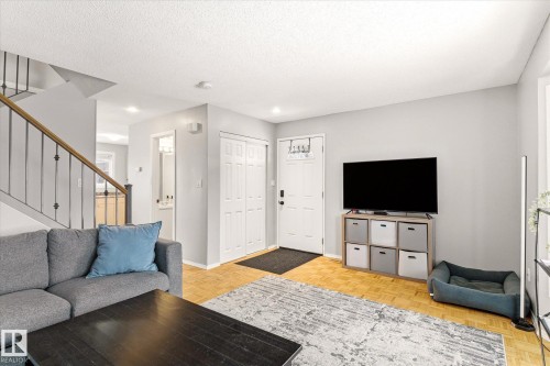 Open living area featuring light wood-finish parquet flooring, light gray wall tones, and recessed lighting - 70 Stirling Road, Edmonton, AB - Indoor Photo Showing Living Room