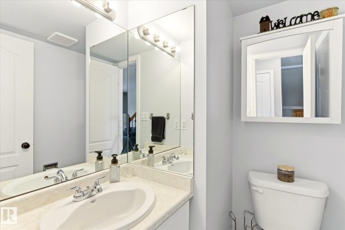 Vanity area featuring a dual-basin sink, chrome fixtures, and a large mirrored wall - 70 Stirling Road, Edmonton, AB - Indoor Photo Showing Bathroom