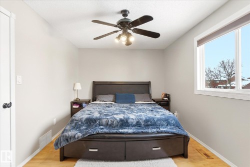 Bright bedroom featuring wood-finish flooring and a ceiling fan with integrated lighting - 70 Stirling Road, Edmonton, AB - Indoor Photo Showing Bedroom