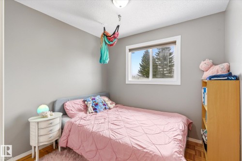 Room featuring light gray walls and wood-finish parquet flooring - 70 Stirling Road, Edmonton, AB - Indoor Photo Showing Bedroom