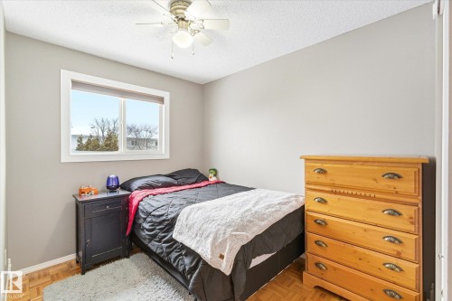 Bedroom featuring light gray walls, wood-finish parquet flooring, and a ceiling fan with integrated lighting - 70 Stirling Road, Edmonton, AB - Indoor Photo Showing Bedroom