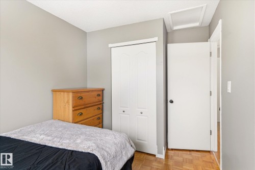 Interior room with light gray walls and wood-finish parquet flooring - 70 Stirling Road, Edmonton, AB - Indoor Photo Showing Bedroom