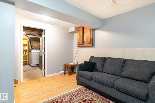 Finished interior space with light wood-finish flooring, a neutral wall color, and wainscoting - 70 Stirling Road, Edmonton, AB - Indoor Photo Showing Living Room