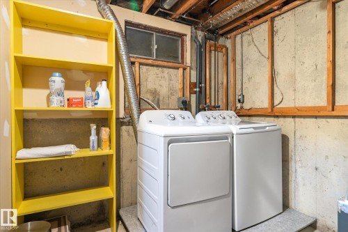 Laundry area with a white washer and dryer pair, an exposed concrete wall, a small window, and a yellow multi-shelf storage unit - 70 Stirling Road, Edmonton, AB - Indoor Photo Showing Laundry Room