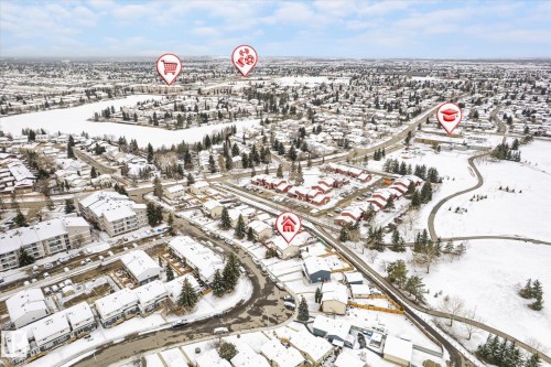 Aerial perspective showcasing a residential area with snow-covered rooftops and trees, a frozen body of water, and surrounding neighborhood infrastructure - 70 Stirling Road, Edmonton, AB - Outdoor With View