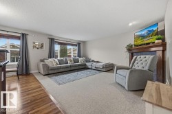 Living area featuring light-toned carpeting and rich wood-finish flooring - 