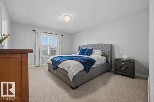 Carpeted room featuring light gray walls, a flush-mount ceiling light, and a window with blinds and drapes - 1613 Kerr Road, Edmonton, AB - Indoor Photo Showing Bedroom