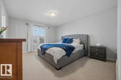 Carpeted room featuring light gray walls, a flush-mount ceiling light, and a window with blinds and drapes - 