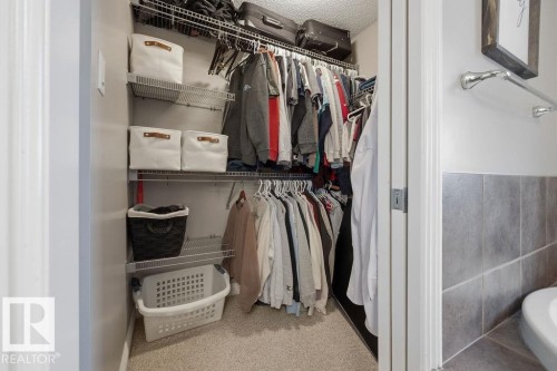 Walk-in closet featuring wire shelving, multiple hanging rods, and carpet flooring - 1613 Kerr Road, Edmonton, AB - Indoor With Storage