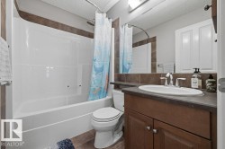 2nd floor -Bathroom featuring a white bathtub and shower combination, a toilet, and a vanity with a white oval sink - 