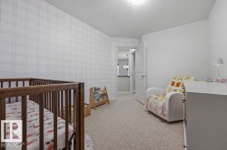 Carpeted room featuring a patterned accent wall and a light-colored ceiling - 