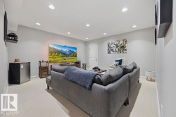 Downstairs Spacious room featuring light-colored carpeting, ample recessed lighting, a built-in wall shelf, and a white interior door - 
