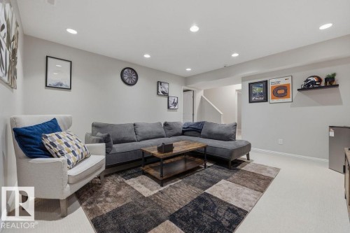 Downstairs Spacious living area featuring recessed lighting, light-toned carpeting, and a visible staircase - 1613 Kerr Road, Edmonton, AB - Indoor Photo Showing Living Room