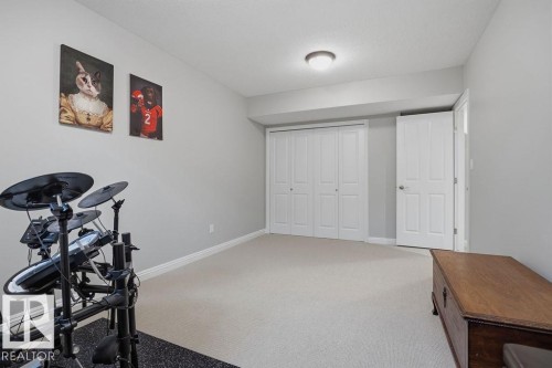 Basement ---Spacious room featuring neutral carpeting, light gray wall paint, and white trim - 1613 Kerr Road, Edmonton, AB - Indoor Photo Showing Other Room