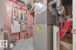 Utility space featuring a furnace, air handler, and electrical panel - 