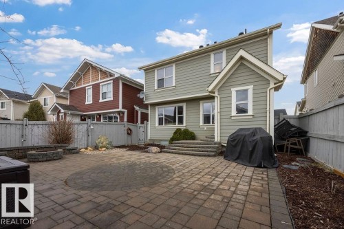 Spacious paver patio with circular inlay, featuring a stone fire pit and built-in stone benches - 1613 Kerr Road, Edmonton, AB - Outdoor